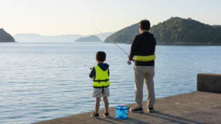 夏の堤防でサビキ釣りを楽しむ家族の後ろ姿と瀬戸内の穏やかな海
