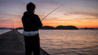 夕暮れの瀬戸内海の堤防でタチウオを狙う釣り人
