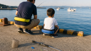 夏の堤防で親子がサビキ釣りを楽しむ情景。手前にサビキ仕掛けとコマセカゴ