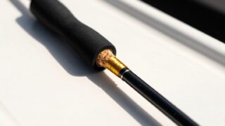 船のデッキに置かれた船竿のグリップとブランクの接写